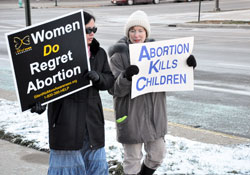 St. Susanna parishioner Judy York of Plainfield, right, and Photini James, a member of Joy of All Who Sorrow Orthodox Church in Indianapolis, carry pro-life signs during a Respect Life March organized by Right to Life of Indianapolis on Jan. 15 at the conclusion of the organization’s annual Memorial Service for the Unborn at the Indiana War Memorial. (Photo by Mary Ann Garber)