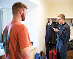 Transitional Deacon Jack Wright, right, an archdiocesan seminarian, blesses the room of new seminarian Quinton Thomas of the Diocese of Little Rock, Ark., on Aug. 19 at Saint Meinrad Seminary and School of Theology in St. Meinrad. (Photo courtesy of Saint Meinrad Archabbey)