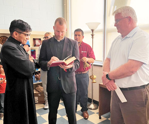 Father Vincent Gillmore, pastor of St. Lawrence Parish in Indianapolis, center, blesses the new prayer room for the Intercultural Pastoral Institute in Indianapolis on Sept. 12. Also shown are Father José Neri, left, parochial vicar at Our Lady of the Greenwood Parish in Greenwood, and Deacon Thomas Hosty, far right, archdiocesan director of pastoral ministries. (Submitted photo)